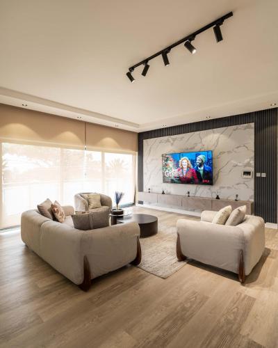 a living room with two couches and a flat screen tv at George Residence SDA Court, Banana Island, Ikoyi in Lagos
