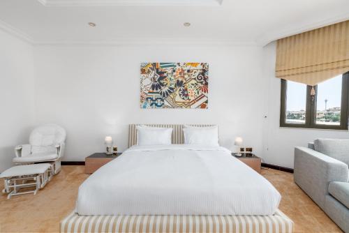 a white bedroom with a bed and a couch at Palm Villa F, Palm Jumeirah - Mint Stay in Dubai
