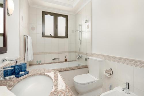a white bathroom with a toilet and a sink at Palm Villa F, Palm Jumeirah - Mint Stay in Dubai