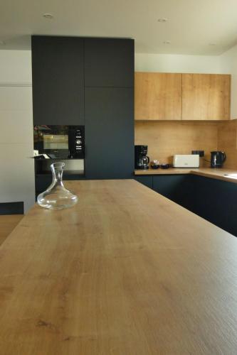 a glass wine glass sitting on a wooden table in a kitchen at L'HACIENDA DUO a romantic getaway with a private spa in Charavines