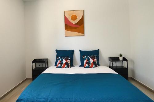 a bedroom with a bed with blue sheets and pillows at L'HACIENDA DUO a romantic getaway with a private spa in Charavines