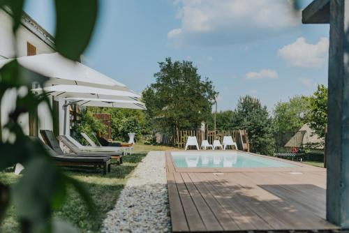 a pool with chairs and umbrellas next to a house at GORIČKE IŽE in Križevci
