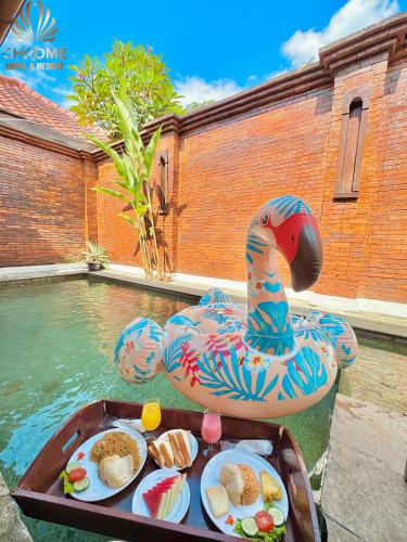 un vassoio di cibo in una piscina con un cigno nell'acqua di chrome hotel & resort solo a Colomadu