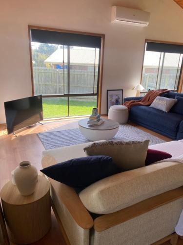 a living room with a couch and a tv at Happy Valley Haven in Sunset Strip