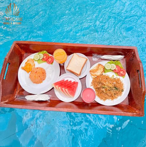 un vassoio di cibo con piatti di cibo in una piscina di chrome hotel & resort solo a Colomadu