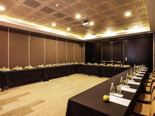 a large conference room with black tables and chairs at Novotel Vina del Mar in Viña del Mar