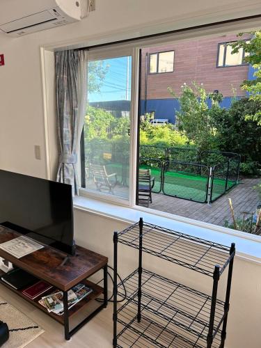 a living room with a large window and a table at 宿中村屋 in Aomori