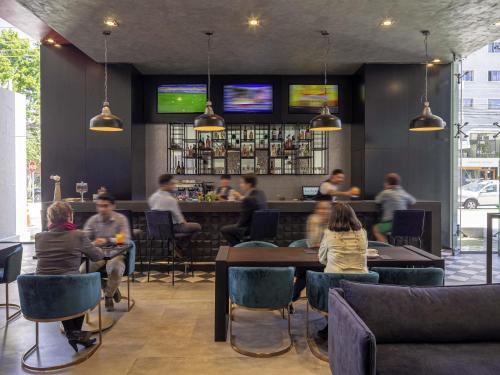 a group of people sitting at tables in a restaurant at Novotel Vina del Mar in Viña del Mar