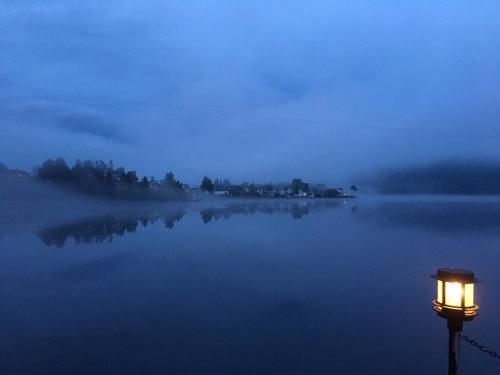 a light pole in the middle of a lake at night at Revsnes Hotel in Byglandsfjord