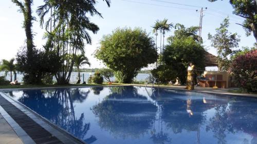 un hombre de pie junto a una piscina en Spring Of Life Ayurveda Resort, en Nikawatawana