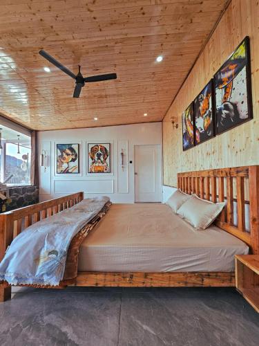 a large bed in a room with wooden walls at Panoramic Jacuzzi Suite with huge Balcony & Swing in Mussoorie