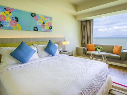 a hotel room with a bed and a view of the ocean at Mercure Penang Beach in George Town