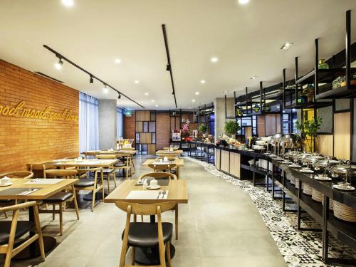a restaurant with tables and chairs and a brick wall at ibis Styles Bekasi Jatibening in Bekasi