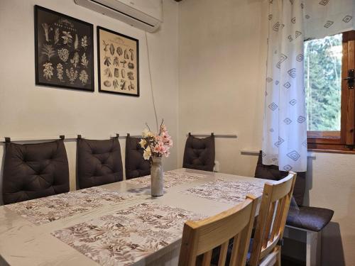 a dining room table with a vase of flowers on it at Chata Mezičky in Jiřetín pod Jedlovou