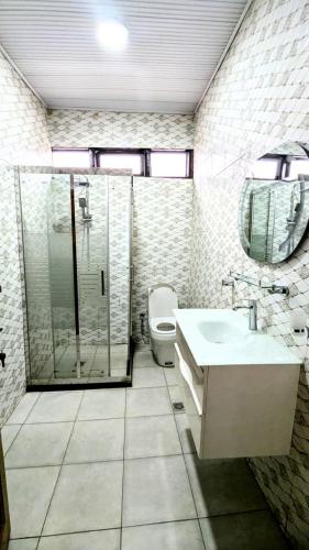 a bathroom with a shower and a sink and a toilet at SILVER RESIDENCE KIGALi in Kigali