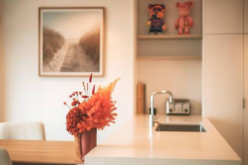 a kitchen counter with a vase of flowers on it at Gleaming Riverfront - Stay on Casino, Free Carpark in Brisbane