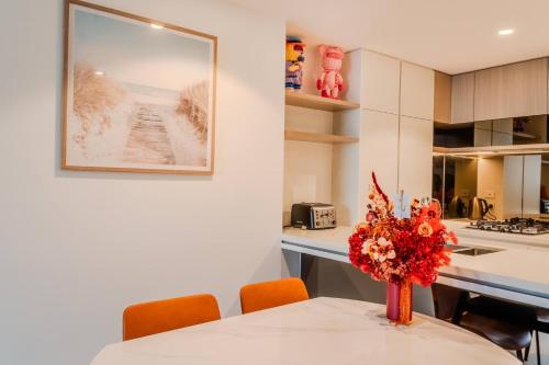 a kitchen with a table with a vase of flowers on it at 2Bedroom Gleaming Riverfront - City view Free Carpark in Brisbane