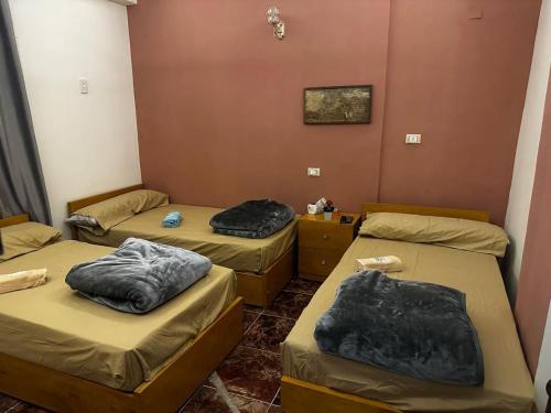 a room with three beds with blankets on them at Alwaha safari hotel in Qasr Al Farafirah
