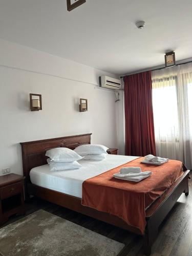 a bedroom with a large bed with a red blanket at Pensiunea Siva in Horezu