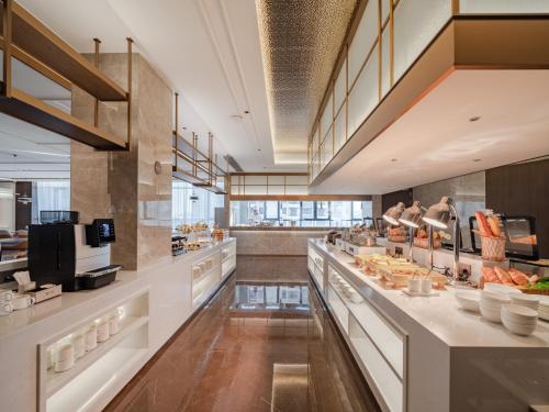 a large kitchen with a buffet line with food at SINOKAI International Hotel in Maqifa