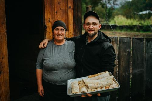 two men standing next to each other with a tray of food at Family Guesthouse Bako in Bako