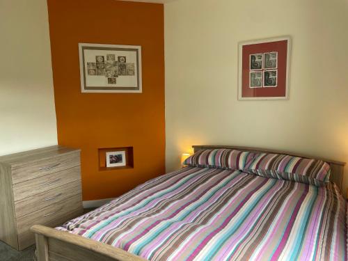 a bedroom with a bed and two pictures on the wall at The Wee Flat in Uphall