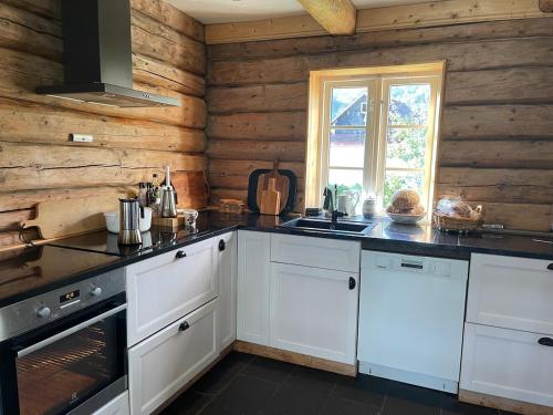 een keuken met witte kasten en een aanrechtblad bij House with oceanview in Stryn