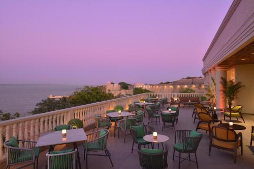 a restaurant with tables and chairs on a balcony at The Fort House, Diu- IHCL SeleQtions in Diu
