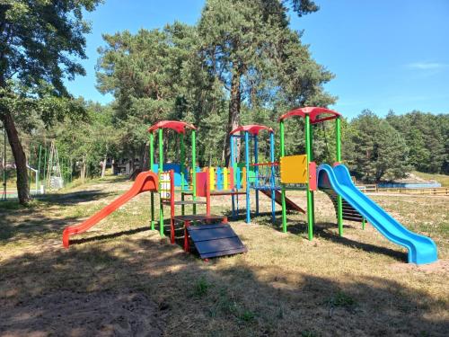 a playground with a colorful play equipment in a park at Domki nad Wierną Rzeką in Bocheniec
