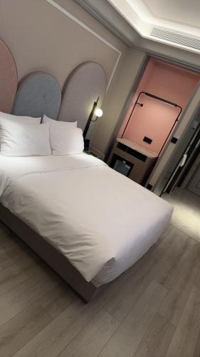 a bedroom with a large white bed and a window at Mercure Guangzhou Financial City in Guangzhou
