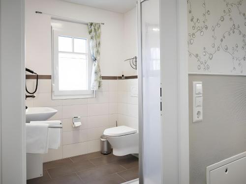 a white bathroom with a toilet and a sink at Ferienhaus Elsa 180 qm in Rust