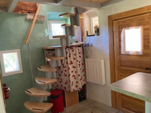 a kitchen with a spiral staircase in a room at Les Eyssaux en Baronnies Provençales in Reilhanette