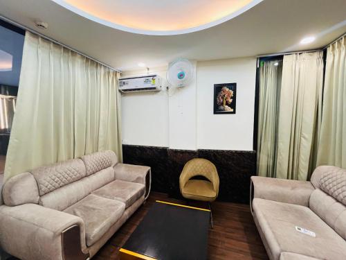 a living room with couches and a table in a room at Hotel Paradise - Near 1 Min Walk in Nizamuddin Railway Station in New Delhi