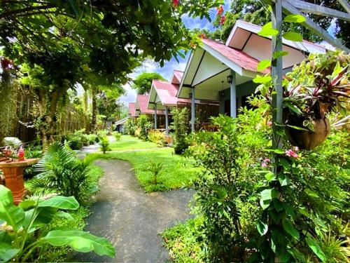 a garden with a house and some plants and trees at THARA PHLU BUNGALOWS Koh Chang in Ko Chang