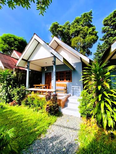 a small white house with a porch and stairs at THARA PHLU BUNGALOWS Koh Chang in Ko Chang