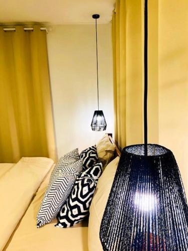 a room with a bed with pillows and a lamp at THARA PHLU BUNGALOWS Koh Chang in Ko Chang