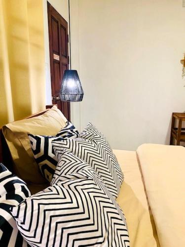 a couch with a black and white blanket on it at THARA PHLU BUNGALOWS Koh Chang in Ko Chang