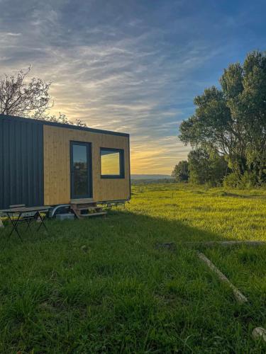 a tiny house sitting in the middle of a field at Tiny-House - 5 min de Montélimar - Salle de bain italienne & grand confort in Châteauneuf-du-Rhône
