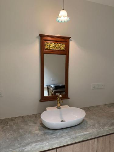 a bathroom sink with a mirror on a counter at LM Motel in Kulim
