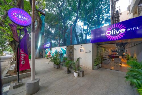 a shop with a purple sign on the side of a building at Olive Hotel Indiranagar 100Ft Road by Embassy Group in Bengaluru