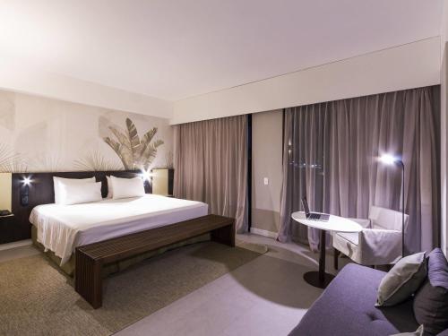 a hotel room with a bed and a desk at Novotel Salvador Rio Vermelho in Salvador