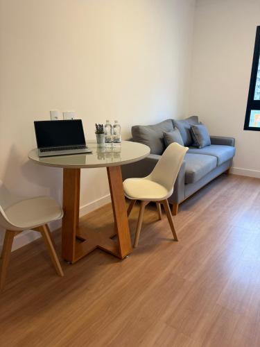 a living room with a table with a laptop on it at Dream Flat Pinheiros in Sao Paulo