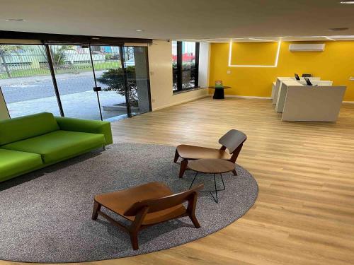a living room with a green couch and chairs at ibis Styles Belem Batista Campos in Belém