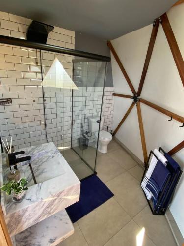 a bathroom with a glass shower and a toilet at Domo com vista do Lago e Montanhas in Igaratá
