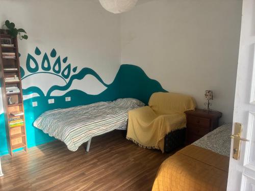 a bedroom with a bed and a chair in it at The Good Vibes Home in Hoya de Pineda