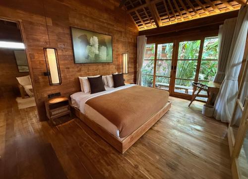 een slaapkamer met een bed in een kamer met houten wanden bij Kaju Villa Canggu in Canggu