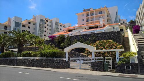 um edifício com flores ao lado de uma rua em Apartments Madeira no Caniço