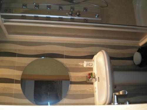 een badkamer met een wastafel en een toilet met een spiegel bij Rincón de Gala in Soria