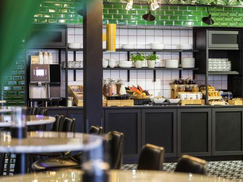 a restaurant with tables and chairs in a room at ibis Styles Amsterdam Airport in Schiphol