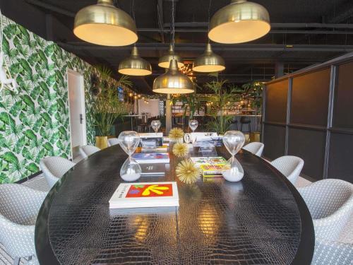 a dining room with a black table and white chairs at ibis Styles Amsterdam Airport in Schiphol